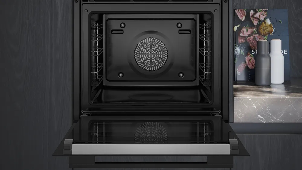 View of the interior of the SIEMENS HB776G1B1 iQ700 built-in oven, door open, showing the fan