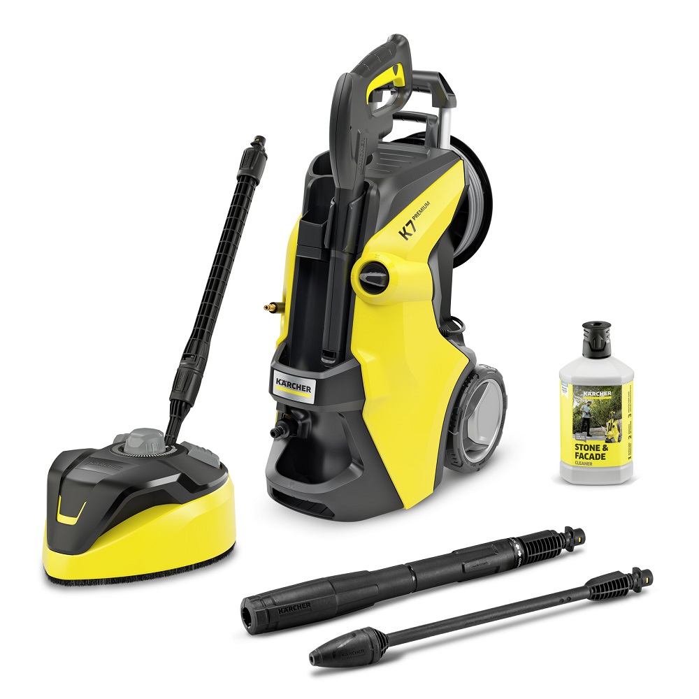Overall view of the Kärcher K7 Premium pressure washer (yellow/black) with T-Racer surface cleaner, Vario Power Jet, dirt blaster, and stone cleaner bottle.