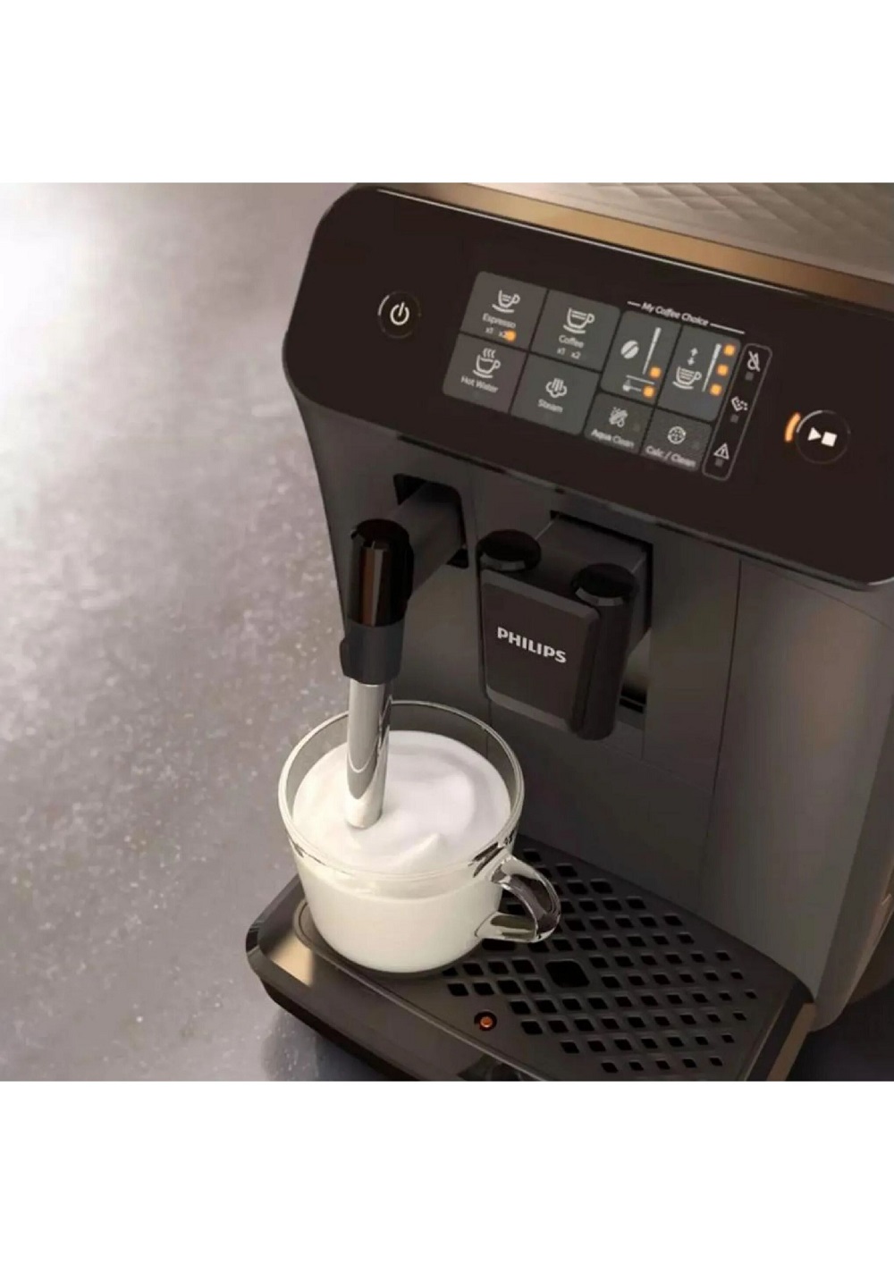 Close-up: Milk being frothed in a glass using the steam wand of the Philips coffee machine.