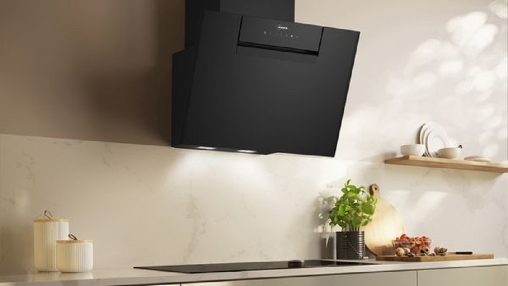 Lifestyle image of the NEFF extractor hood over a hob, integrated into a bright, modern kitchen design.