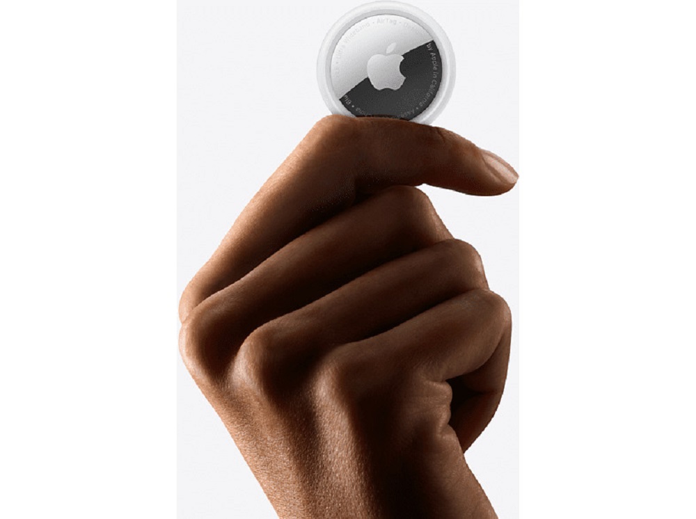 Apple AirTag held in hand, showing compact size.