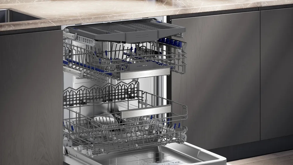 Side view of the open dishwasher showing the bottom basket, top basket, and the Vario cutlery drawer.