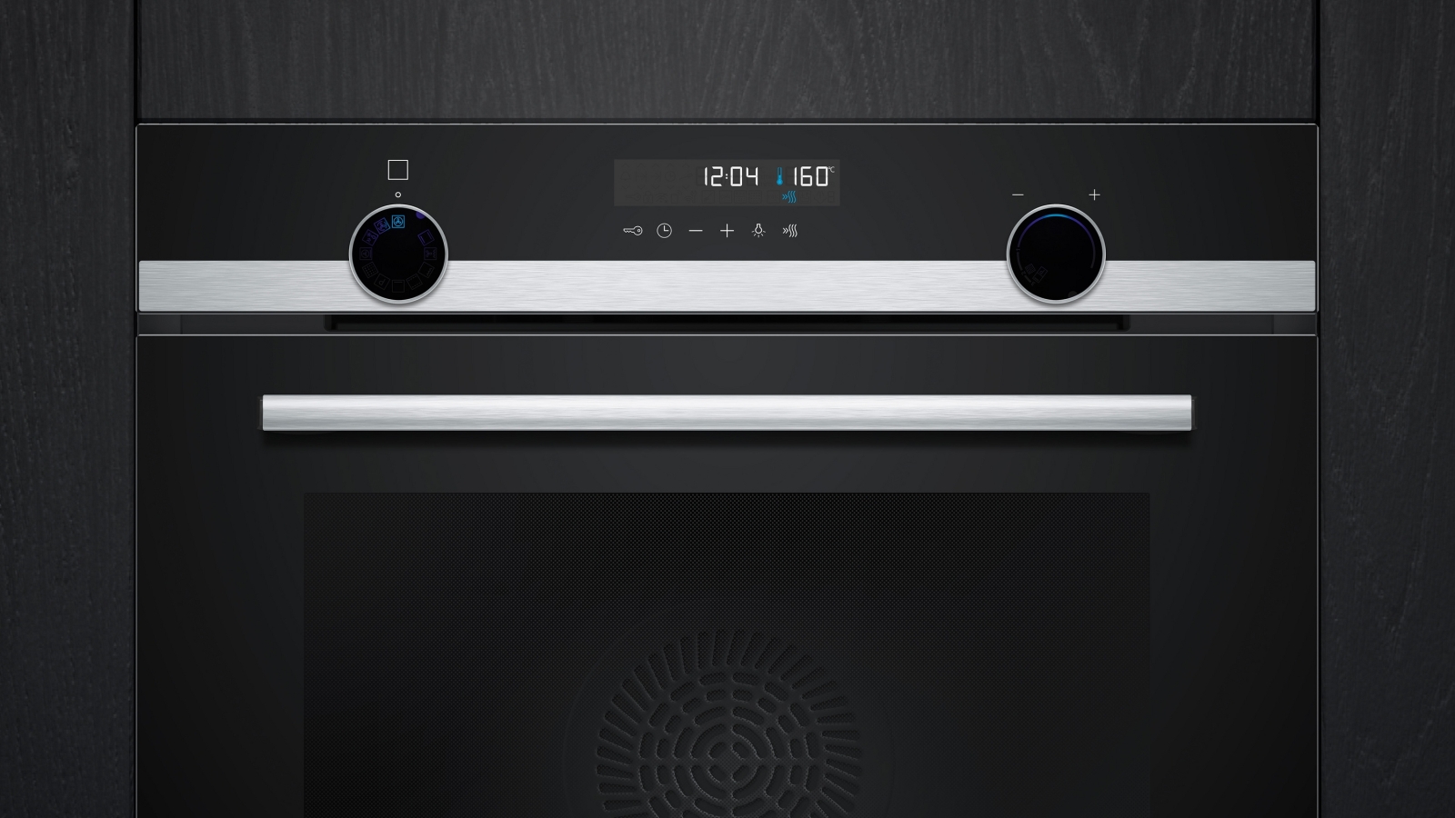 Close-up of the control panel with the digital display showing time, temperature (160°), and the retractable black and silver rotary knobs.