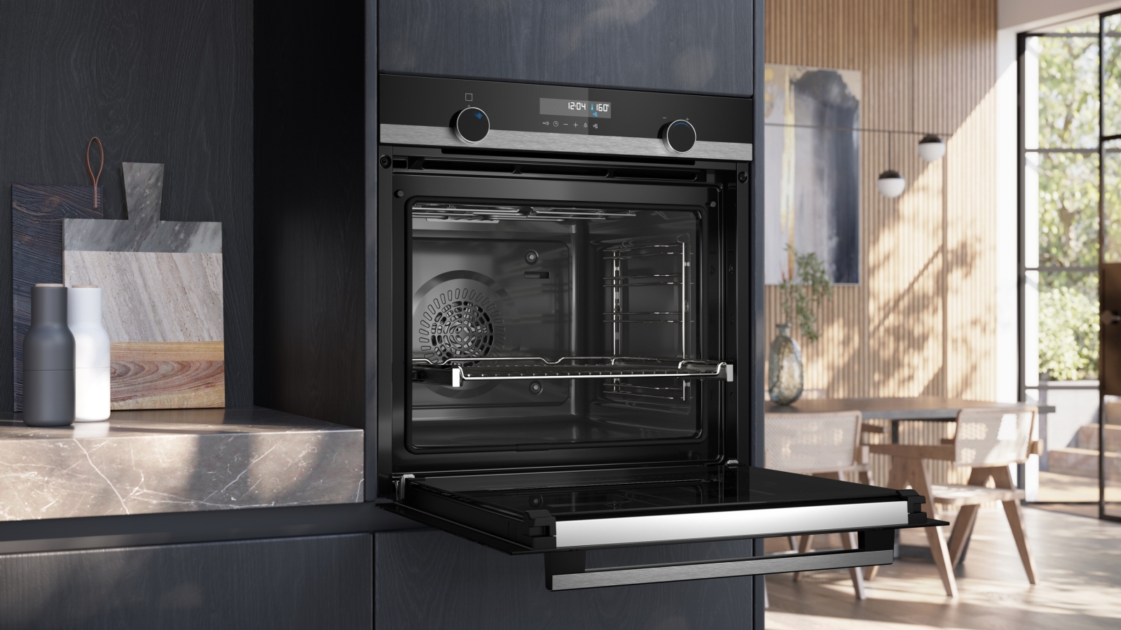 The Siemens oven integrated into a dark kitchen, with the door fully open, revealing the interior cavity and a wire rack.