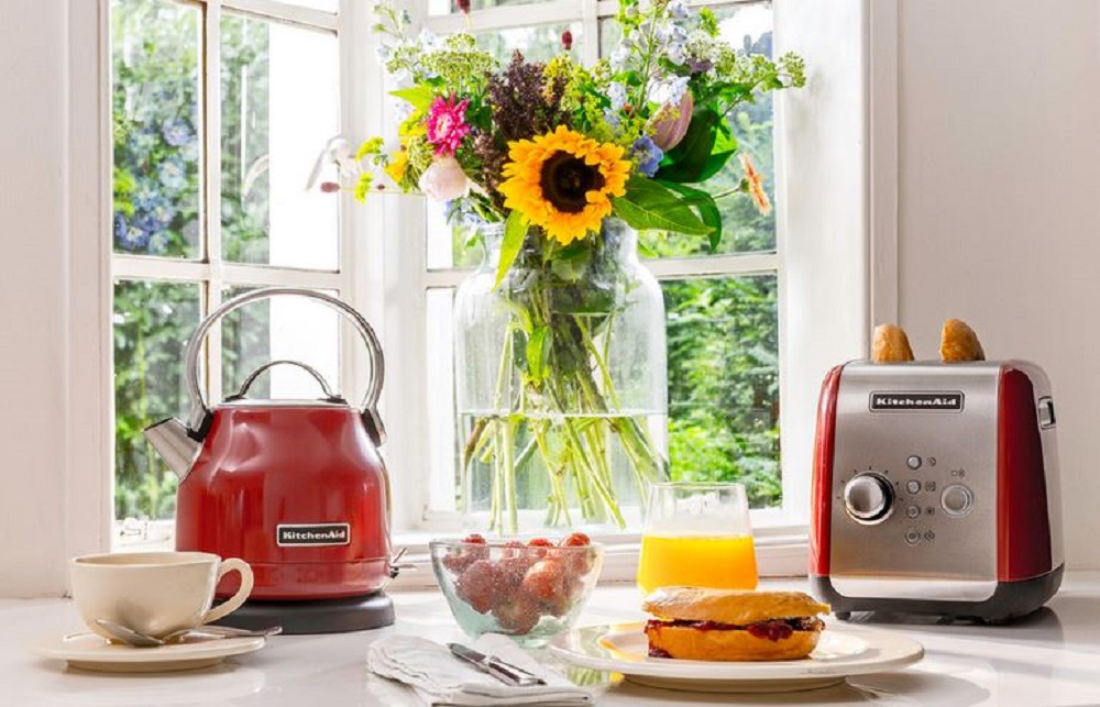 KitchenAid 5KEK1222EER kettle in Empire Red alongside a matching toaster on a kitchen countertop