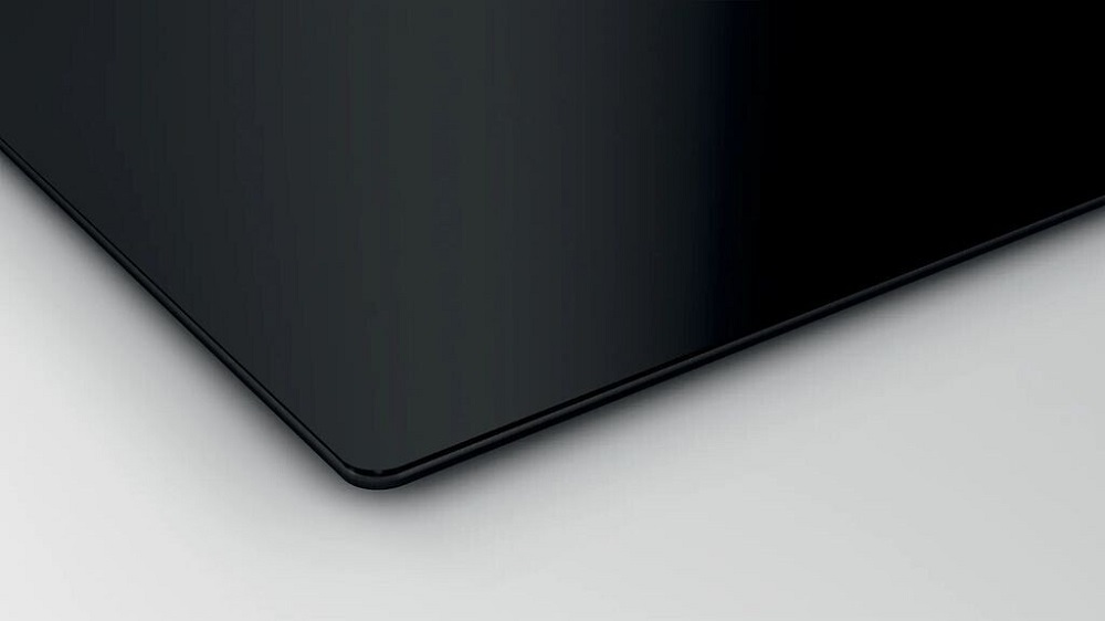 Detailed view of the Bosch hob's glass ceramic surface with an elegantly rounded edge (frameless design).