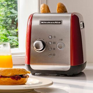 KitchenAid 5KMT221EER toaster in Empire Red, lifestyle image on a kitchen countertop in use.