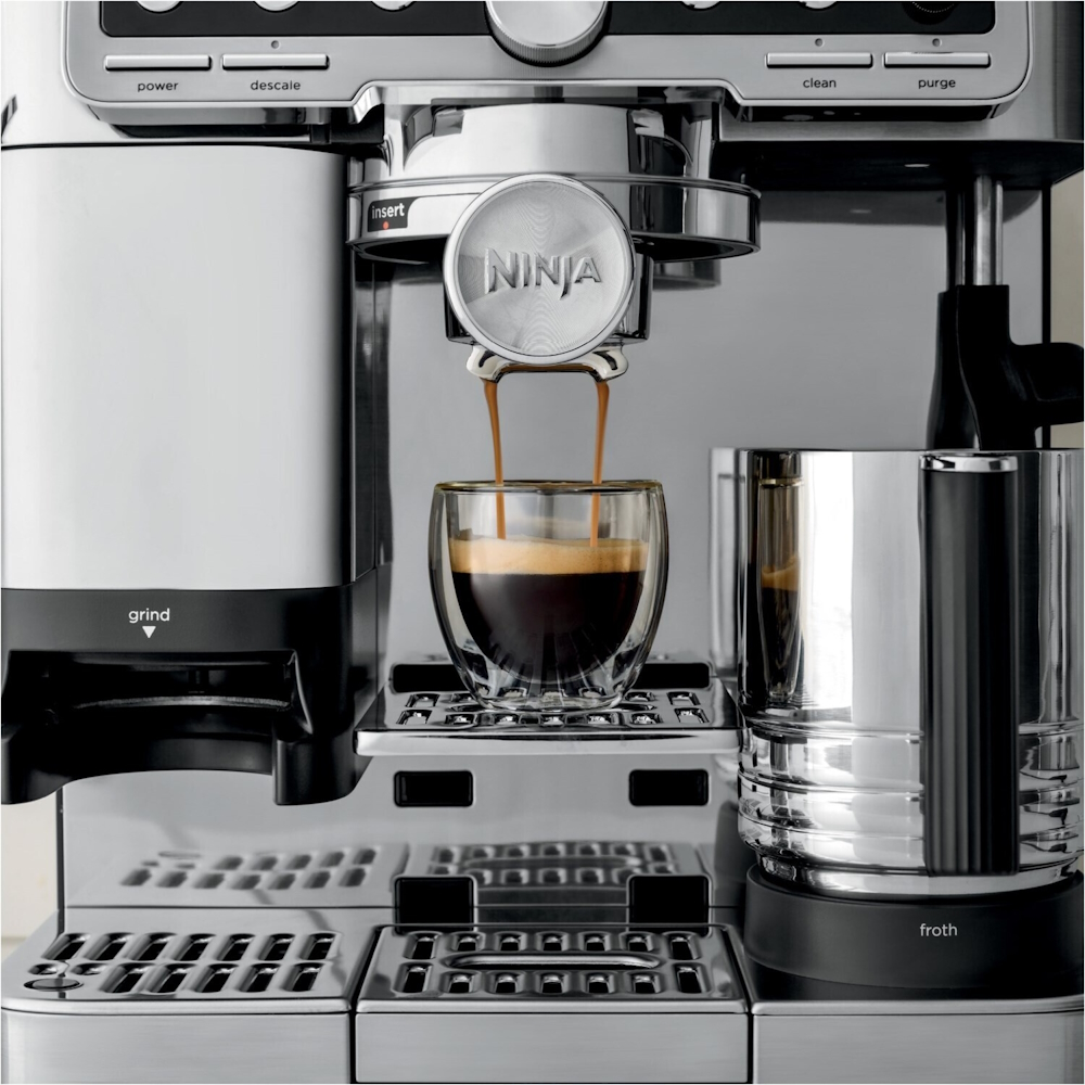 Detail view of the NINJA ES701EU dispensing freshly brewed espresso into a double-walled glass